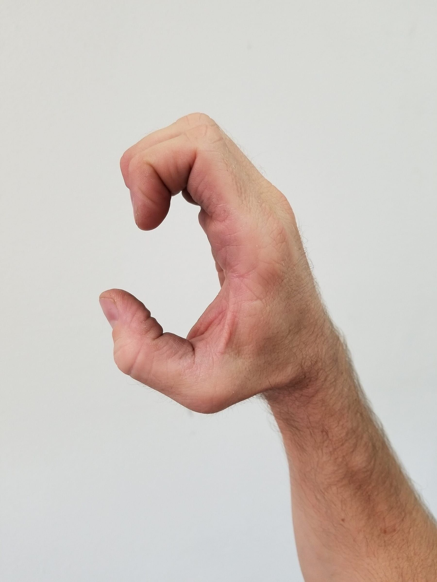 Nahaufnahme einer Hand in der Adlerkrallen-Stellung aus dem Kung Fu vor hellem Hintergrund