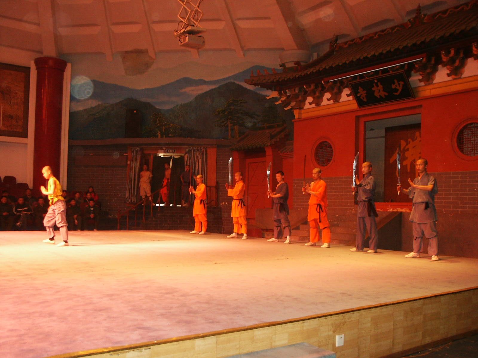 Kung-Fu-Darsteller in orangefarbener Kleidung bei einer Bühnenvorführung im Shaolin-Tempel in Dengfeng, China