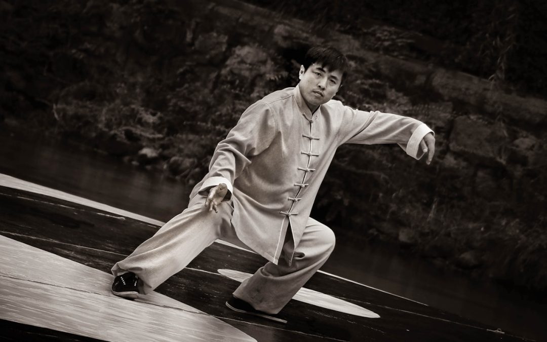 man in white robe sitting on wooden dock